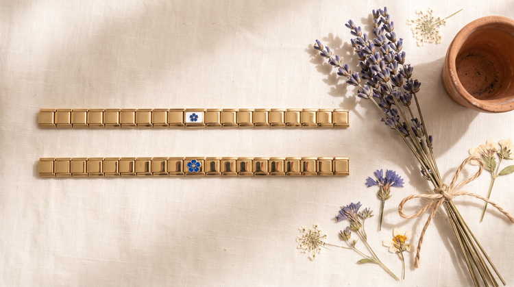 Goldene Italian Charm Armbänder mit Blaue-Blume- und Kornblume-Charm, umgeben von Lavendel, Trockenblumen und Terrakotta-Topf