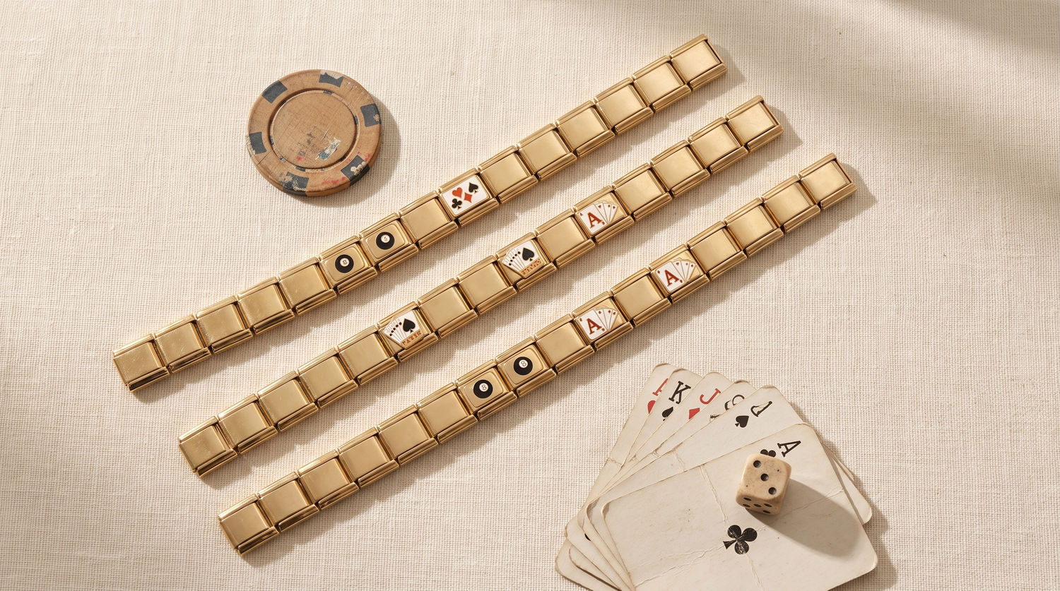 Goldene Italian Charm Armbänder mit Poker- und Billard-Charms, umgeben von Spielkarten, Würfel und Pokerchip